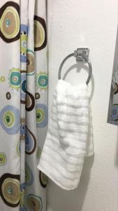 a white towel hanging on a curtain rod at Cozy studio apt in Orlando