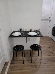uma mesa preta com duas cadeiras e pratos em Cozy studio apt em Orlando