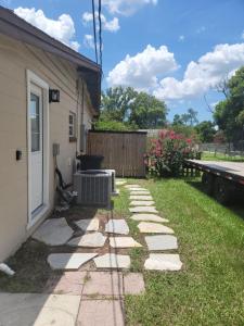 un patio trasero con una pasarela de piedra junto a una casa en Cozy studio apt en Orlando