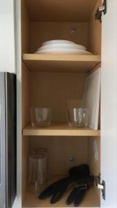 a cabinet with some bowls and utensils in it at Cozy studio apt in Orlando