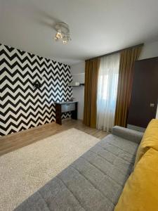 a bedroom with a bed and a chevron wall at Happy Time 1 in Petroşani +8 photos