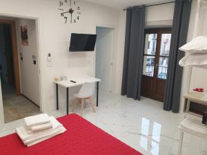 Habitación con alfombra roja, mesa y escritorio. en Cafe del peso, en Cavour