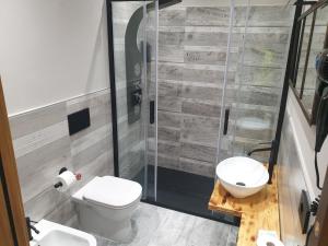 a bathroom with a toilet and a glass shower at Cafe del peso in Cavour +16 photos