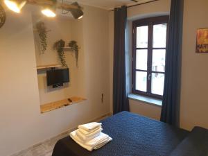 een slaapkamer met een bed, een raam en handdoeken bij Cafe del peso in Cavour