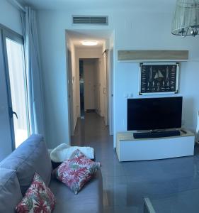 sala de estar con sofá y TV de pantalla plana en Precioso apartamento en la zona Norte de La Manga., en La Manga del Mar Menor