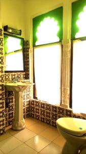 a bathroom with a toilet and a sink and a mirror at Bundi Inn - A Heritage Boutique Haveli in Būndi