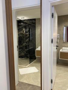 een badkamer met een glazen deur naar een douche bij Marinus Hotel in Ulcinj