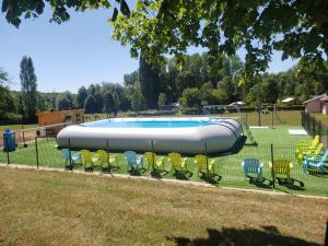 a pool with chairs around it in a park at Gite Le Bois Fleuri in Illiers