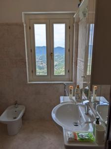 ein Bad mit einem Waschbecken, einem WC und einem Fenster in der Unterkunft B&B La casetta in Poggio Bustone