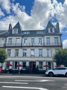 ein weißes Auto, das vor einem Gebäude parkt in der Unterkunft Logis Regina in La Bourboule