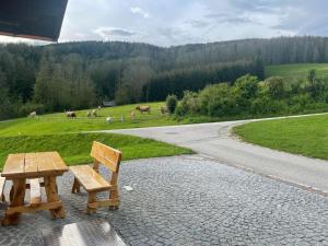 una mesa de picnic y un banco a un lado de una carretera en Ferienwohnung ,Hoizmann`, en Pinsdorf