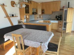 a kitchen with a table with chairs and a table and a table at Ferienwohnung ,Hoizmann` in Pinsdorf