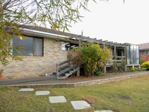 a brick house with a staircase in front of it at Derwent Vista in Austins Ferry