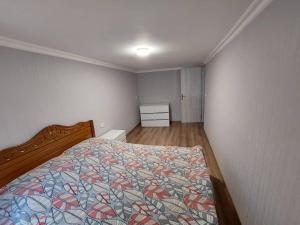 a bedroom with a bed with a colorful quilt at Davids entire place in Borjomi