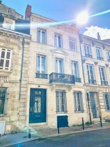 ein großes Steingebäude mit grüner Tür an einer Straße in der Unterkunft B&B La Maison Galiène in Bordeaux