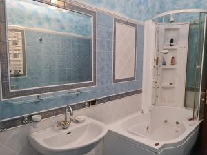 a bathroom with a sink and a mirror and a tub at Appartamento Deluxe Centrale, in Gaeta