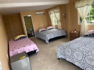 1 dormitorio con 2 camas con sábanas rosas y azules en Posada Miss Portia, en Providencia