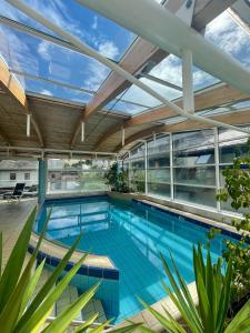 an indoor swimming pool with a glass ceiling at Logis Regina in La Bourboule