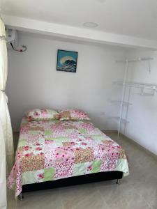 1 dormitorio con 1 cama con edredón rosa en Posada Miss Portia, en Providencia
