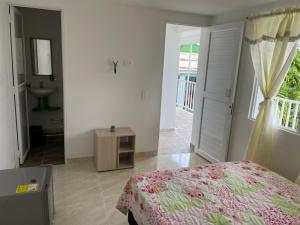 um quarto com uma cama e uma casa de banho com um lavatório em Posada Miss Portia em Providencia