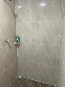 una ducha con una gran pared de azulejos y una botella de jabón. en Posada Miss Portia en Providencia