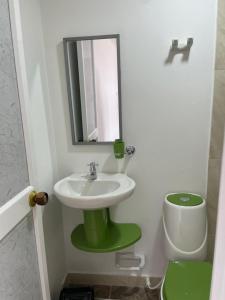 a bathroom with a sink and a mirror and a toilet at Posada Miss Portia in Providencia