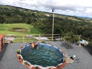two people sitting in a large pool of water at CAMPING LOS ROBLES POPAYÁN in Florencia