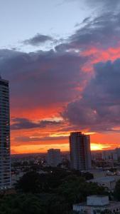 um pôr-do-sol sobre uma cidade com edifícios altos em Lindo flat Easy Life em Goiânia