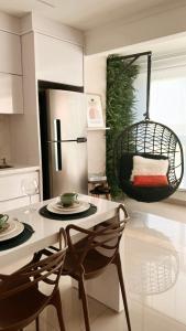 uma cozinha com uma mesa e cadeiras e um frigorífico em Lindo flat Easy Life em Goiânia