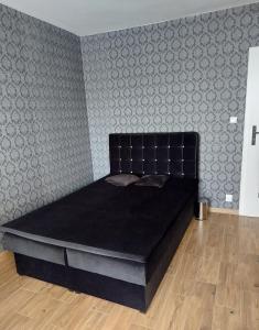 een bed met een zwart matras in een kamer bij Apartament Chopina 17 in Włocławek