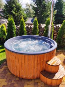 una bañera de hidromasaje de madera con un banco en un patio en Chalupy Vichrovky, en Bělá pod Pradědem