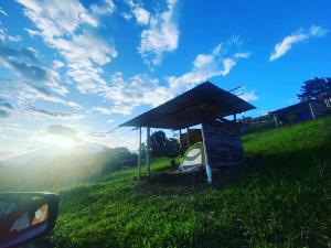 a small building in a field with the sun in the sky at CAMPING LOS ROBLES POPAYÁN in Florencia