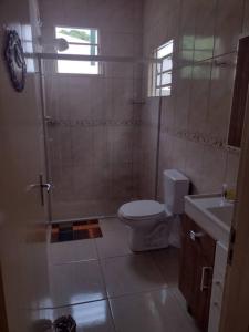 uma casa de banho com um chuveiro, um WC e um lavatório. em Sua Casa na Cidade dos Canyons - Cambará do Sul-RS em Cambará