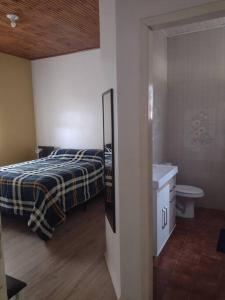 um quarto com uma cama, um lavatório e um WC em Sua Casa na Cidade dos Canyons - Cambará do Sul-RS em Cambará