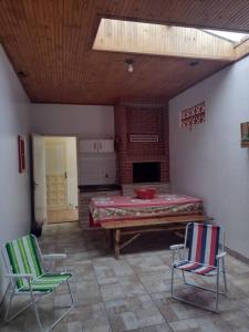 um quarto com duas cadeiras e uma mesa num quarto em Sua Casa na Cidade dos Canyons - Cambará do Sul-RS em Cambará