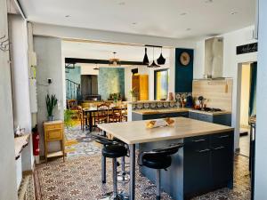 a kitchen with a island with stools in it at Villa Kundalini - Guest House in Vincelles