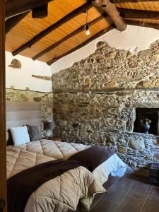 um quarto com uma cama numa parede de pedra em Quinta da Meda em Coimbra