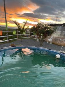a large swimming pool with a sunset in the background at CAMPING LOS ROBLES POPAYÁN in Florencia