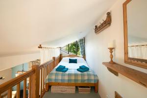 a bedroom with a bed with blue pillows on it at Canny Brow Barn Garden Rooms in Kendal