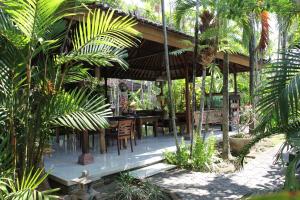 a pavilion with a table and chairs in a garden at Bumi Ayu Bungalow Sanur in Sanur