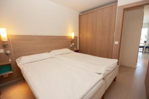 a bedroom with a large white bed with a wooden headboard at Superior 2 bedroom penthouse, almost on the beach. in Mogán