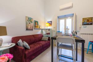 a living room with a red couch and a table at Casa Parravano - Dimora storica vicino alla Reggia in Caserta