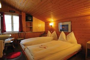 A bed or beds in a room at Hotel Schützen Lauterbrunnen