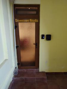 オラデアにあるDowntown Studioの褐色のドア(ダウンタウンスタジオを読むサイン付)
