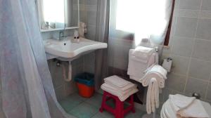 a bathroom with a sink and a toilet with towels at Hotel Bellavista S'Archittu in S'archittu Cuglieri