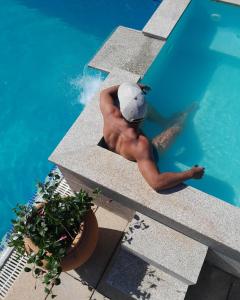 a man in a cap sitting in a swimming pool at Villa Silene in Covilhã