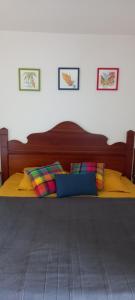 un letto con cuscini gialli e blu in una camera da letto di BO SOLEY, studio vue mer Les Hauts de Caritan a Sainte-Anne