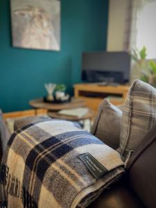 a couch with a blanket on top of it at Allanvale Holiday Home in Inverness
