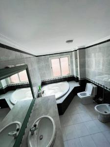 Beautiful Villa Casablanca في الدار البيضاء: حمام به مغسلتين وحوض استحمام ومرحاض