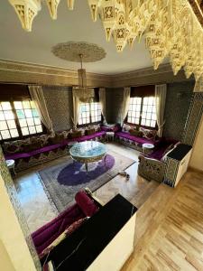 a living room with purple furniture and a glass table at Beautiful Villa Casablanca in Casablanca